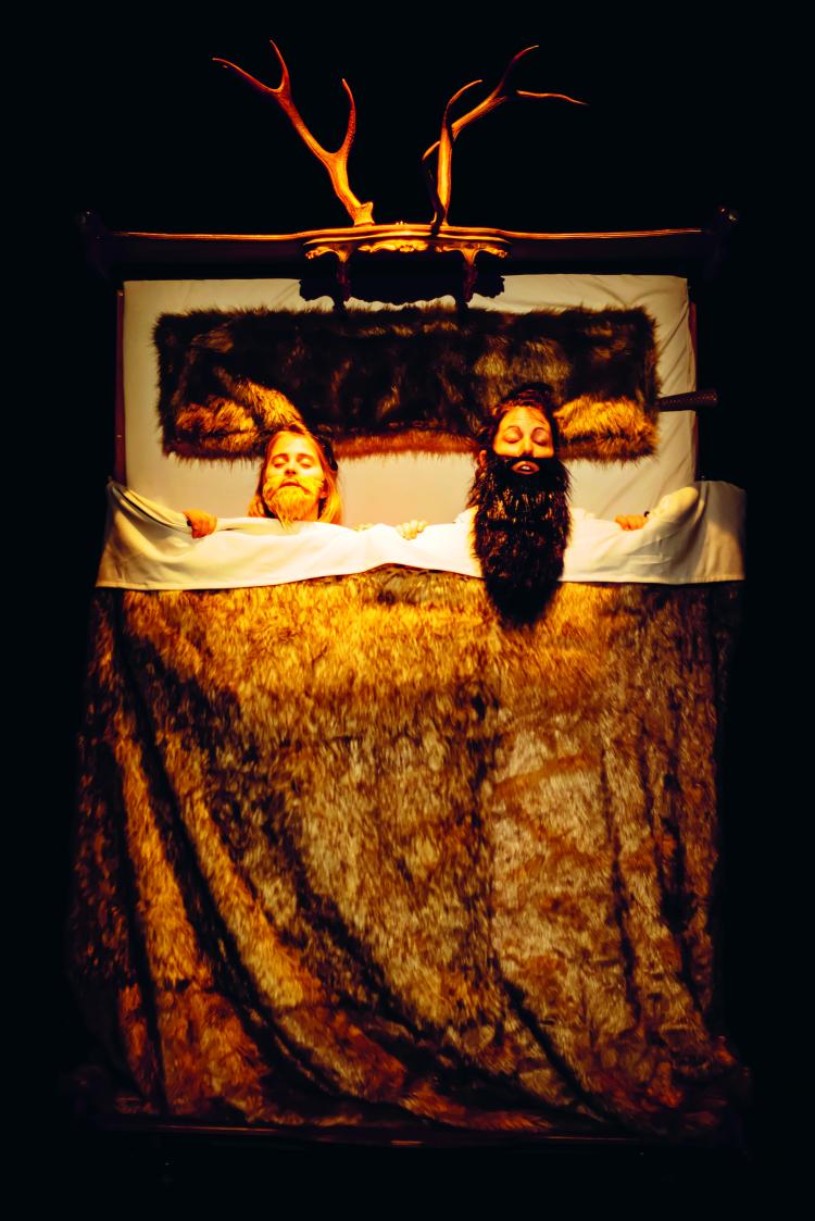 deux personnages sont allongés dans un lit, visage vers le haut, l'un ressemble à un ogre de contes de fées