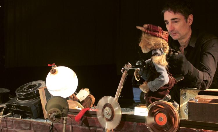 Photo du spectacle montrant un comédien qui anime une marionnette